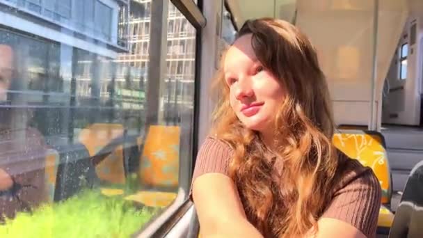 Ragazza Cavalcando il treno non c'è nessuno Lei è sola lei è in un abito marrone bella con i capelli biondi per strada, primavera, alberi flash by, video al rallentatore, lei pensa — Video Stock