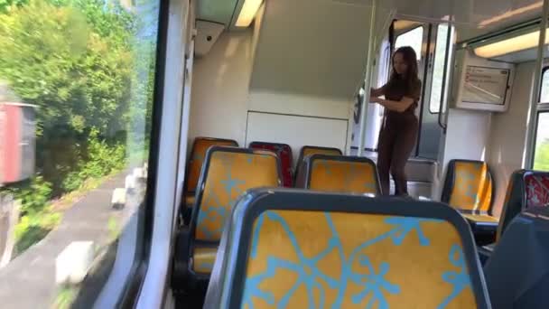 Dziewczyna jazda w pociągu nie ma nikogo ona jest sama ona jest w brązowym garniturze piękny z blond włosy na ulicy, wiosna, drzewa migają przez, powolny film, ona myśli — Wideo stockowe