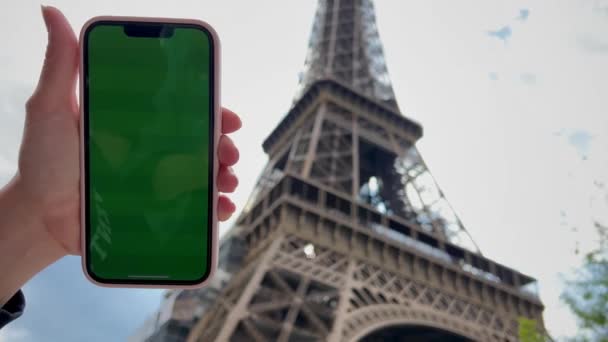 Girl looks at the phone lifting it up with chromate blonde natural hair developing green screen flipping her finger against the background of a beige building — Vídeo de Stock