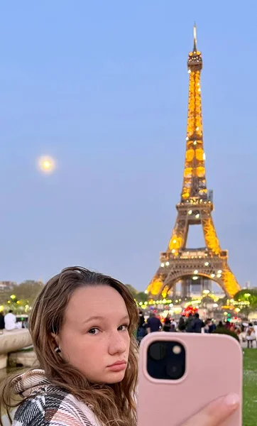 A teenage girl stands against the backdrop of the Eiffel Tower, it is possible to use it for some kind of advertising for a travel company — Stock Photo, Image