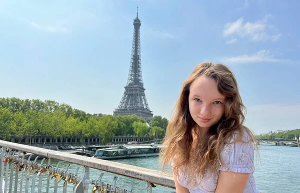 Tierna cara de una chica con pecas de cerca ella tiene el pelo rubio y los ojos brillantes Ella mira y se puede utilizar para cualquier publicidad ent hay un lugar para el texto Torre Eiffel en el fondo — Foto de Stock