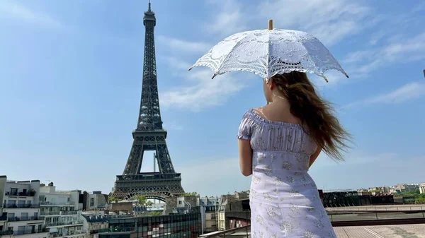 Něžná tvář dívky s pihami zblízka má blond vlasy a světlé oči Ona vypadá a může být použit pro jakoukoli reklamu tam je místo pro text Eiffelova věž v pozadí — Stock fotografie