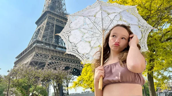Tender face of a girl with freckles close-up she has blond hair and bright eyes She looks and can be used for any advertisem ent there is a place for text Eiffel Tower in the background — Stock Photo, Image
