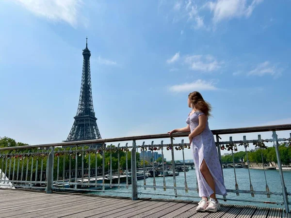 The face of a beautiful girl she is sad leaning on her arm in the distance you can see the Eiffel Tower the girl is young she is a teenager — Foto Stock