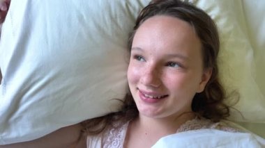 Genç bir kız beyaz bir yastığa uzanır ve gülümseyerek çerçeveye bakar. Soğuk algınlığı ya da alerjisi geçmiştir. İyileştiği için mutlu olmuştur.