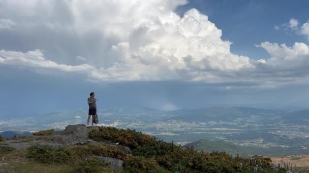 Człowiek stojący na szczycie góry relaksujący i cieszący się pięknym letnim krajobrazem górskim. Panoramiczny widok na Góry Dymne Portugalia — Wideo stockowe