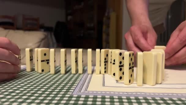 Spelen domineert de handen van een meisje en de handen van een man bouwen dominostenen — Stockvideo
