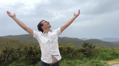 Avrupalı görünümlü bir adam gökyüzünü işaret eder. Burada her yöne bir metin koyabilirsiniz. Önce ellerini sağa kaldırır, sonra sola bakar ve çok mutlu olur. Yüksek kalite 4k görüntü