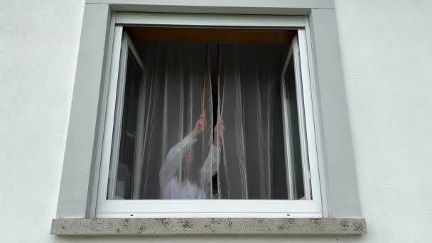 Une Adolescente Divise Les Rideaux Blancs Regarde Par Fenêtre Blanche — Video
