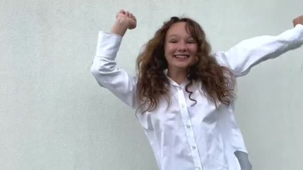 Teenage Girl White Shirt Jumps Dances Waves Her Arms Background — Stock Video