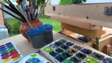 Ressamın şu anda çizmekte olduğu tablonun arka planına karşı çok farklı fırça uçları var. Ressamın gerçekten resim yaptığı bir fotoğraf var. Yüksek kalite fotoğraf