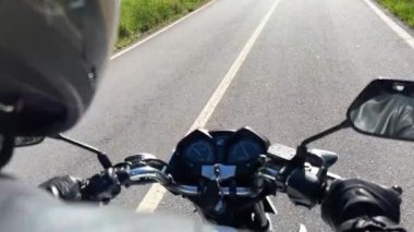 Adam motosiklet sürüyor, kask videonun sol tarafında görünüyor, ve bazen direksiyon ve yol görülebilir, mesajlaşmak için bir yer var, arkadan ateş etmek için. 4k