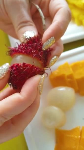 女性の手を開いて真ん中を取るスリランカランブタンの熱帯果実 高画質映像 — ストック動画