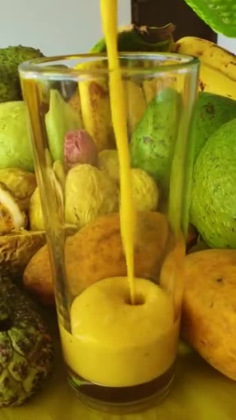 Frullato Giallo Vivo Frutta Tropicale Versato Bicchiere Vetro Sullo Sfondo — Video Stock