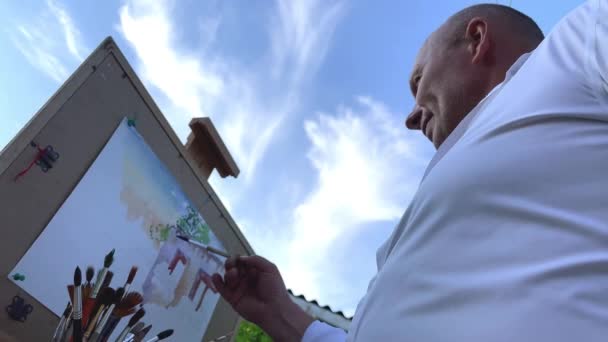 Yetişkin Erkek Sanatçı Yaşlarında Bir Resim Çiziyor Önündeki Eve Bakıyor — Stok video