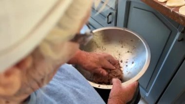 Büyükanne 80 yıldır aşkla köfte hazırlıyor. Ailenin koruyucusu, beyaz bir eşarp takıyor ve mavi bir ceket giyiyor. Mutfakta oturuyor ve meyveli börek ve meyveli börek yapıyor.