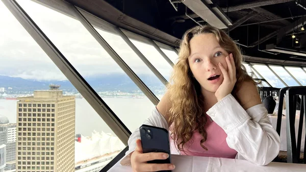 Teenage Girl White Shirt Blond Hair Sits Looks Iphone Phone — Stock fotografie