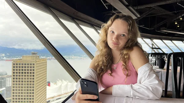Nastolatka Białej Koszuli Blond Włosami Siedzi Patrzy Telefon Iphone Jest — Zdjęcie stockowe