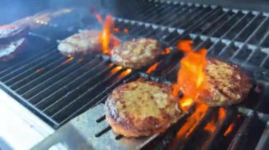 Açık ateşte pişmiş bir hamburger için barbekü ve kızarmış kıymalı kıymalı köfteler ve ateşte pişirilmiş bir spatulayla çok lezzetli bir dönüş. Ateş yanıyor ve çok lezzetli..