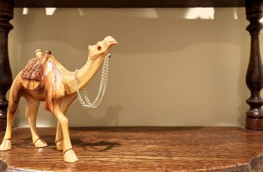 Devenin ahşap bir heykeli fotoğrafın bir tarafında duruyor. Metin için yer var. Boynunda altın bir zincir var.