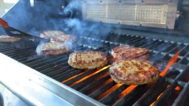 Açık ateşte pişmiş bir hamburger için barbekü ve kızarmış kıymalı kıymalı köfteler ve ateşte pişirilmiş bir spatulayla çok lezzetli bir dönüş. Ateş yanıyor ve çok lezzetli..