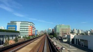 Tren, ön camdan gelen başka bir hava trenine doğru ilerliyor. Bu Vancouver 'daki sürücüsüz metro treni. Kanada, Surrey' den geliyor.