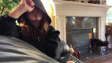 a banner teenager sits in the right corner and looks at a black phoneand she is busy can be used for any problem of adolescence as well as online learning. banner a lot of space for text on the left 