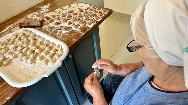 Добрая Бабушка Голубой Блузке Белом Шарфе Готовит Пироги Другое Тесто — стоковое фото