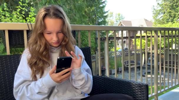 Teenage Girl Gray Hoodie Sits Veranda Terrace Looks Phone She — 图库视频影像