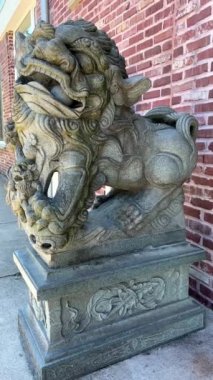 Stone statue of a Chinese lion in the port with a ball school of public policy and Global Affairs office of the ombudsperson institute os asian research institute of european studies pasific affairs.