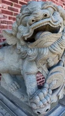 Stone statue of a Chinese lion in the port with a ball school of public policy and Global Affairs office of the ombudsperson institute os asian research institute of european studies pasific affairs.