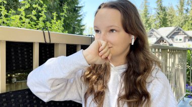 Genç bir kız utançla güldü yumruğuyla yüzünü kapladı, gözleri gülüyordu, dudakları bir elle kaplıydı utanç verici bir gülümseme bastırılmış bir gülümseme.