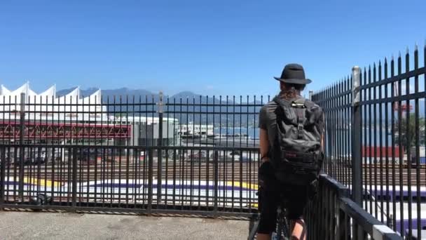 Мужчина Турист Велосипеде Сидит Спиной Камере Смотрит Вдаль Через Забор — стоковое видео