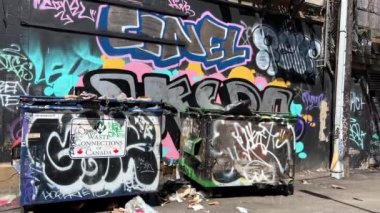 Graffiti on a wall On garbage cans painted with different colors Bad neighborhood Vancouver The area where the homeless and drug addicts live Vancouver Canada 07.2022. High quality 4k footage