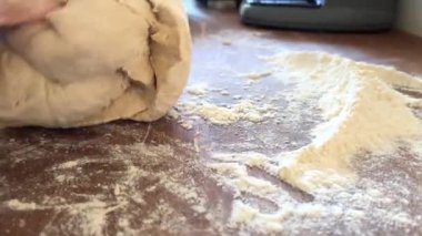 Yaşlı bir kadının yaşlı elleri hamuru yuvarlar ve bir şeyler pişirir ya da hamur köftelerini ya da hamur köftelerini ahşap bir yüzeyde kaynatır. Yüksek kalite 4k görüntü