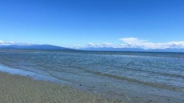 the coast of the Pacific Ocean on Vancouver Island, it can be seen that there was a low tide and now the calm of the wave is barely splashing on the amulet calm silence Rathtrevor Beach, Parksville.