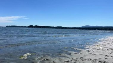 the coast of the Pacific Ocean on Vancouver Island, it can be seen that there was a low tide and now the calm of the wave is barely splashing on the amulet calm silence Rathtrevor Beach, Parksville.