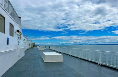 The upper deck of the ferry departing from Canada to Vancouver Island is a clean white deck with a blue flag white stripes on a blue background This is the flag of the ferry everywhere sea-ocean.