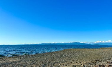 complete calm no wind no waves on pacific ocean looks like a lake on Vancouver island blue water silence calm tranquility and peace great place to relax background Parksville beach Surfside RV resort