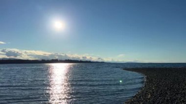 the sun is setting over stone beach the reflections of sun are visible on the water of the Pacific Ocean is very quiet and calm there are no waves relaxing music background for titles and advertising