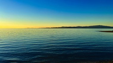 sunset on Ocean Calmness and silence is like a lake or sea on resting in trailers on the shore bright colors of dark blue orange stripe on the horizon from sun rich space for text travel advertising