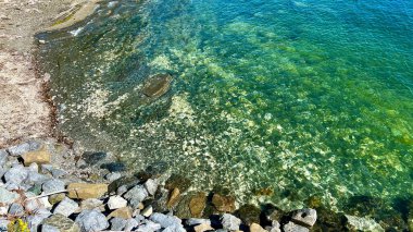 Green water and rocks visible at the ferry station that will sail from Danman Island to Vancouver Island Clear water to Emerald the water of the bay between vancouver and vancouver island
