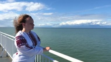 Ocean sea girl is standing alone on liner and is very happy she is returning home she fled from Ukraine war Now Ukraine has won she can return home to her parents IDPs and refugees return to Ukraine