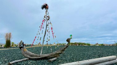 Handmade ship made from dry branches Seashell beads and a pirate flag Against the backdrop of the ocean The wind blows the shiny hair of the head that is worn at the main match Place for text