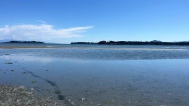 the coast of the Pacific Ocean on Vancouver Island, it can be seen that there was a low tide and now the calm of the wave is barely splashing on the amulet calm silence Rathtrevor Beach, Parksville.
