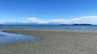 the coast of the Pacific Ocean on Vancouver Island, it can be seen that there was a low tide and now the calm of the wave is barely splashing on the amulet calm silence Rathtrevor Beach, Parksville.