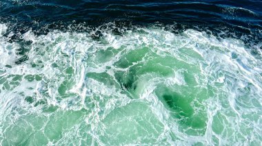 Bright green churning sea with white foam background for any text swatches of trasparent gel on green ash color background beauty hyaluronic acid or antibacterial gel. High quality photo
