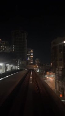 night Train is traveling on road towards another skytrain coming from front window this is driverless subway train is coming from Surrey Slow motion is visible All around. canada Vancouver 07.2022