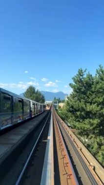 Train is traveling on road towards another skytrain coming from the front window this is driverless subway train is coming from Surrey Slow motion video is visible All around. canada Vancouver 07.2022