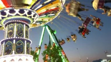 People riding on spinning swing carousel in amusement park.Swing rides are the earliest forms of carousels. They existed in ancient Byzantium and were made with ropes and baskets Playland PNE Canada